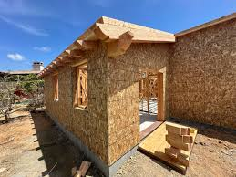 A house under construction with a sunset backdrop, showcasing the progress of ADU construction.