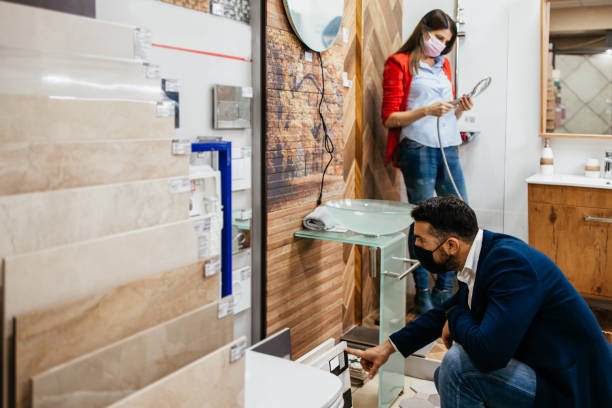 A man and woman examine a modern sink in a bathroom, discussing details for a remodel project.