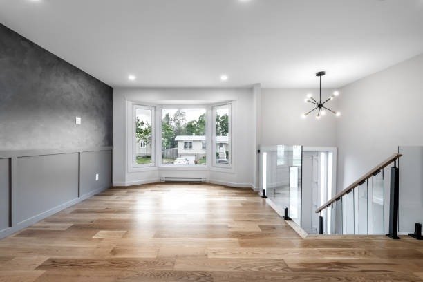 A modern home featuring hardwood floors and a staircase, showcasing a clean design after a full renovation.