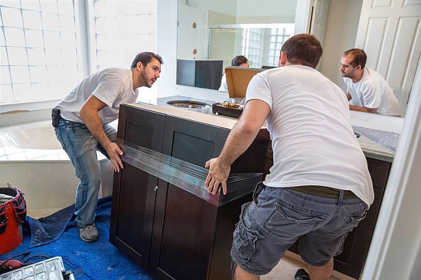 Two men focused on constructing a bathroom cabinet as part of a remodeling effort.